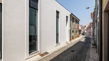 Une ruelle pavée étroite, bordée d’immeubles dotés de grandes fenêtres et présentant un mélange de styles architecturaux.