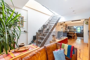A spacious living area with a staircase, a kitchen, and a dining area. - Stunning Belsize Park Home near Hampstead (London)