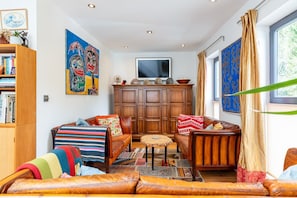 A cozy living room with a sofa set, a coffee table, and a television. - Stunning Belsize Park Home near Hampstead (London)