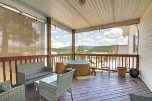 A covered outdoor deck with wicker furniture, a hot tub, and a view of a mountainous landscape. - Hot Tub Haven w/ Mtn Views in Dtwn Pagosa Springs (Pagosa Springs)