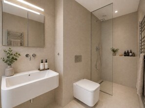 Ein modernes Badezimmer mit einem großen Waschbecken, einer Toilette und einer Duschkabine.