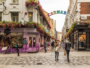 A street with shops, a purple building, and a sign that reads 'CARNAB'. - AC 2 Bed Stylish Covent Garden Flat | Central London (London)