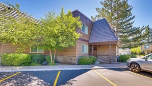 A building with a sloped roof, a parking lot with marked spaces, and a tree in front. - Renovated Tahoe Keys Getaway Near Lake & Heavenly (South Lake Tahoe)