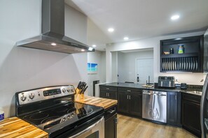 Eine moderne Küche mit Edelstahlgeräten, Holz Arbeitsplatten und einem eingebauten Backofen.