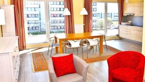 Um apartamento moderno com área de jantar, cozinha e janelas amplas.