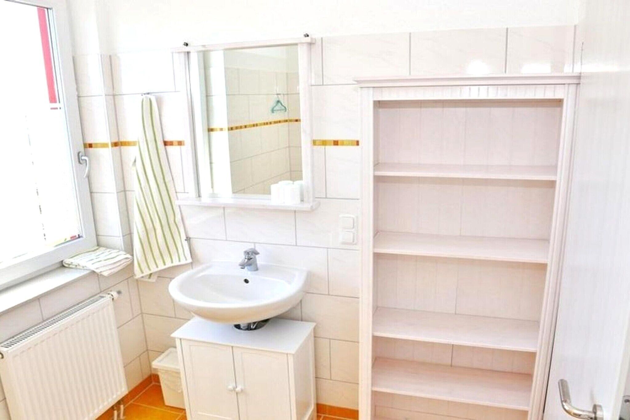 A bathroom with a white sink, a mirror, and a white cabinet.