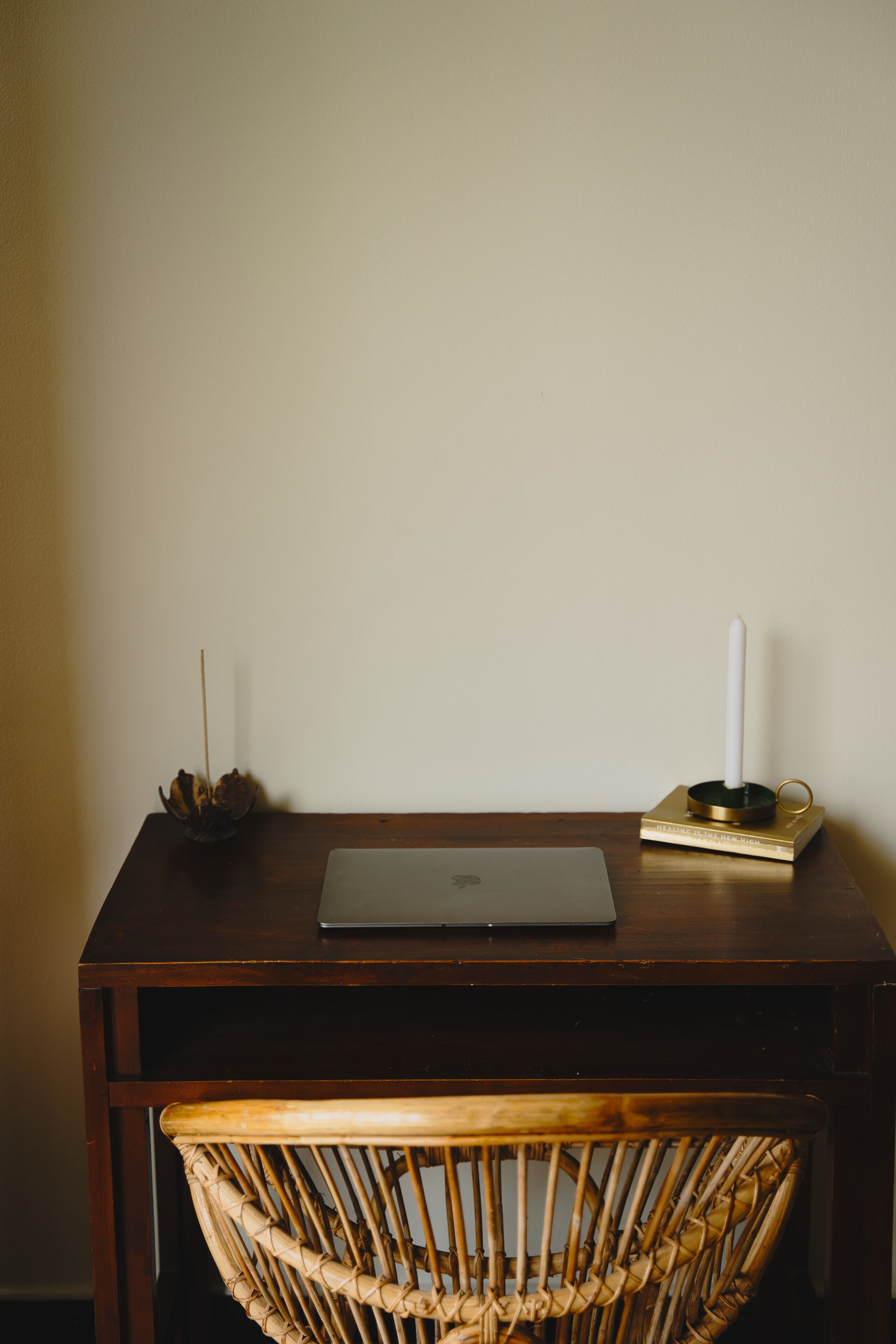Ein Holztisch mit einem Laptop, einer Kerze und einem dekorativen Gegenstand.