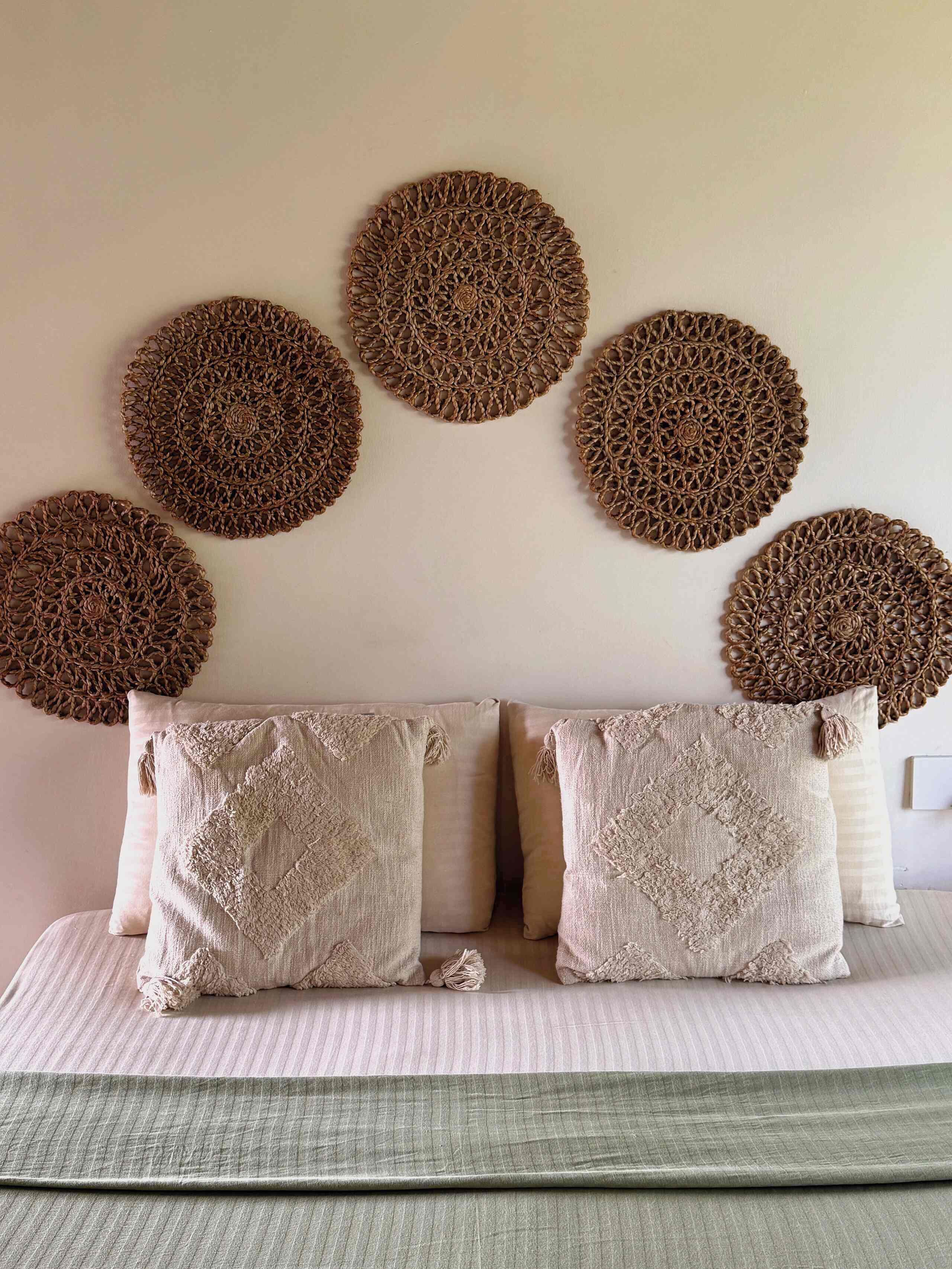 A bed with two pillows and a green bedspread.