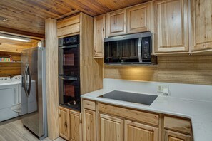 A kitchen with wooden cabinets, a stainless steel refrigerator, a built-in oven, and a microwave. - Boat Dock & Ramp! Brazos River Couple’s Retreat (Granbury)