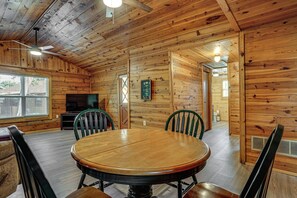 A wooden interior with a round dining table, chairs, a television, and a wooden ceiling. - Boat Dock & Ramp! Brazos River Couple’s Retreat (Granbury)