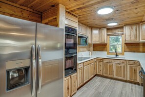 A modern kitchen with wooden cabinets, stainless steel appliances, and a built-in oven. - Boat Dock & Ramp! Brazos River Couple’s Retreat (Granbury)