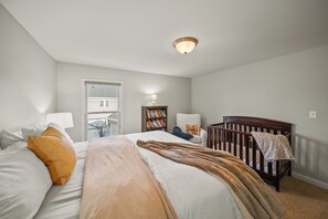 A bedroom with a bed, a crib, a window, and a bookshelf. - < 1 Mi to Geist Park & Beach! Playroom & Patio (McCordsville)