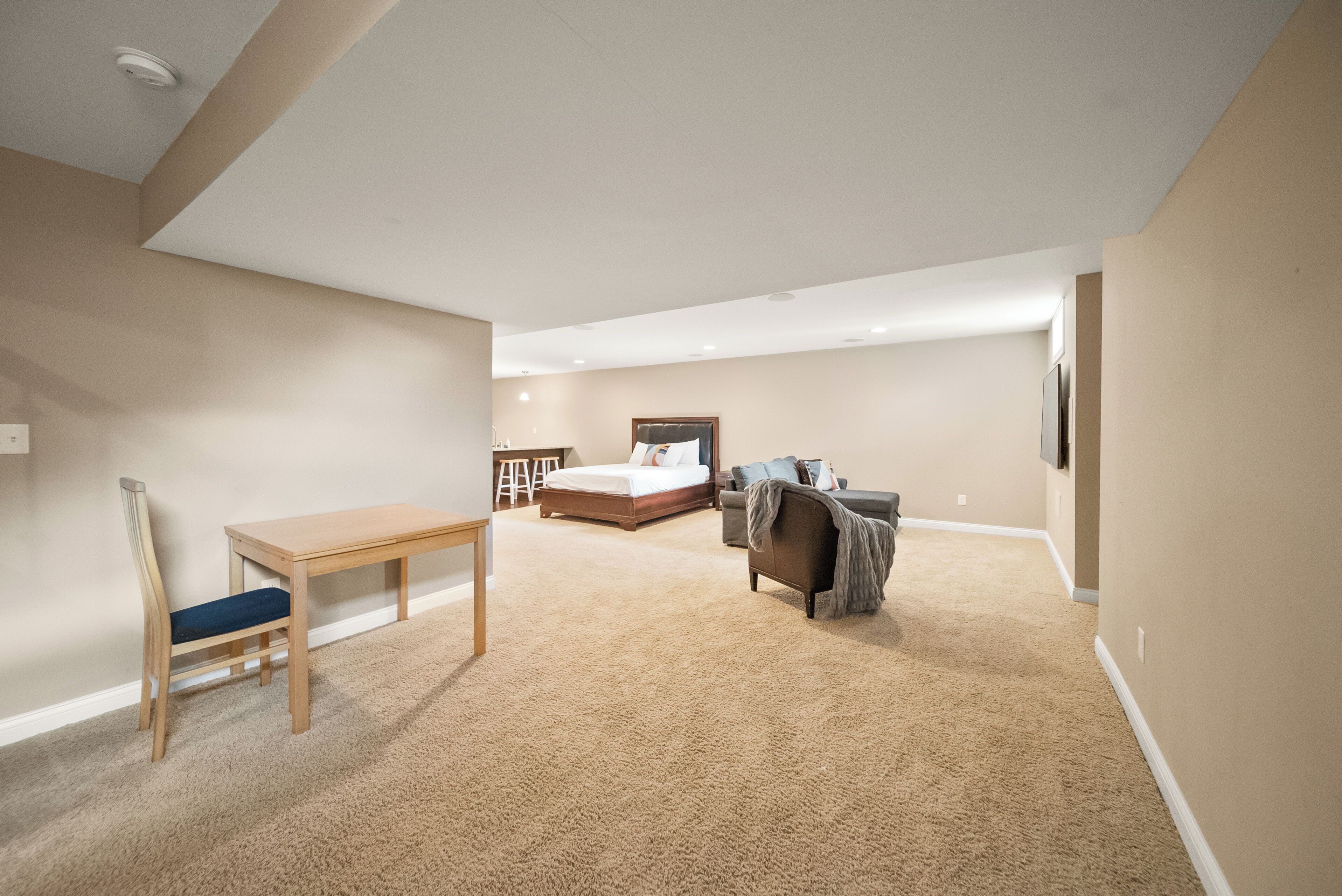A bedroom with a bed, a desk, and a chair.