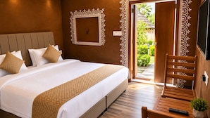 Un dormitorio bien equipado con una cama grande, un banco de madera, un control remoto y una planta en maceta.