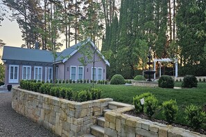 A two-story house with a stone retaining wall and a well-manicured lawn.