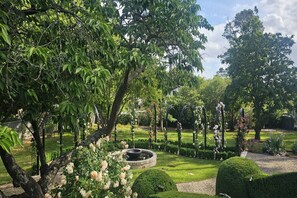 A well-maintained garden with a circular water feature, neatly trimmed hedges, and flowering plants. - Balnagowan, Garden Retreat 3-Bed Home in Moss Vale (Moss Vale)