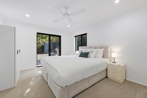 Una camera da letto con un letto, un comodino e una ventola a soffitto.
