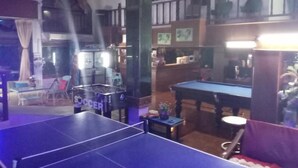Une pièce équipée d’une table de ping-pong, d’un billard et d’un canapé.