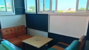 Une pièce avec un canapé, une petite table et une fenêtre donnant sur un beau paysage.