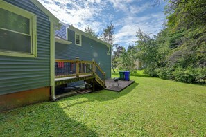 En bostadsfastighet med en inglasad veranda, en liten utegrill och en välskött gräsmatta.