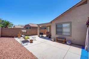 A residential backyard with a patio, a swing chair, a table, and a grill. - Backyard Billiards & BBQ! Surprise Desert Stay (Surprise)