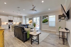 A modern living room with a sofa, coffee table, and a TV mounted on the wall. - Twin Ocala Townhomes! 1 Mi to WEC (Ocala)