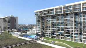 A multi-story hotel with balconies, a swimming pool, and a view of the surrounding area. - Gulf-Front SPI Condo: Suntide III - Unit 1009 (South Padre Island)