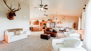 A spacious living room with a fireplace, a dining area, and a kitchen with wooden cabinets.