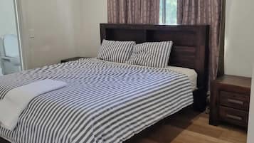 Tabla de planchar con plancha, internet y ropa de cama