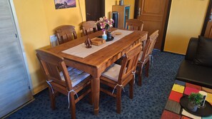 Una mesa de comedor de madera con seis sillas, un jarrón con flores y una pequeña cesta.