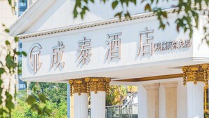 Un cartel de hotel con caracteres chinos y un estilo arquitectónico clásico con columnas.