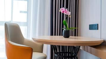 Een moderne kamer met een ronde tafel, een stoel en een potorkidee.