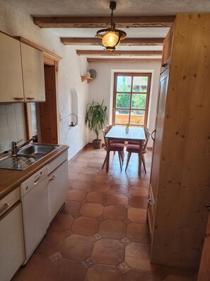 A kitchen with a wooden countertop, a sink, and a dining area with a table and chairs. - Vacation Rental III, 58 square meters, for 4 people. 2 separate bedrooms and bathrooms (Rottau)
