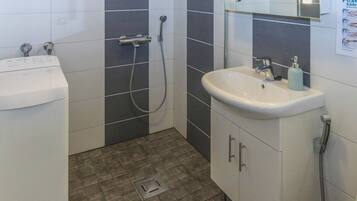 A bathroom with a toilet, sink, and shower.