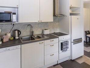 A compact kitchen with a microwave, sink, toaster, and a small oven.