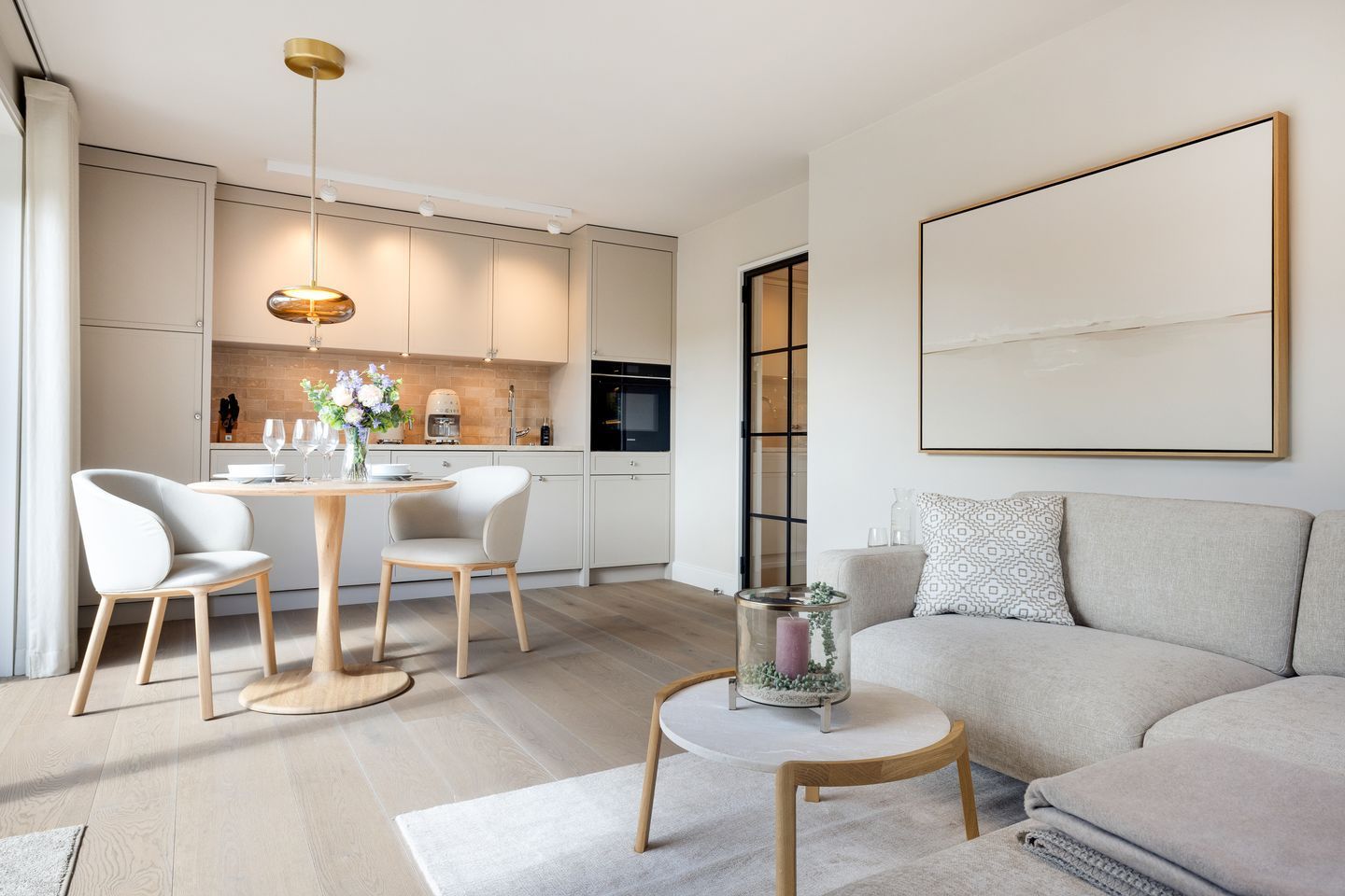 Un salon moderne comprenant un canapé, une table basse et un coin repas avec des chaises et une table.
