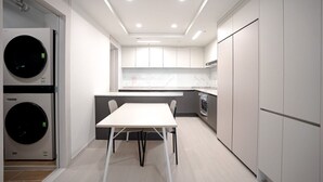 A modern kitchen with built-in appliances, a dining area, and a laundry machine. - Nambu-Terminal Station Gangnam - 2 Bedroom Apartment - #NewBuilding #Clinic (Seoul)
