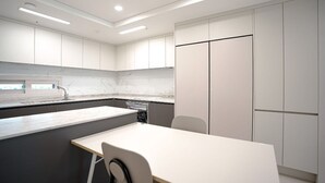 A modern kitchen with white cabinets, a marble countertop, and a built-in dishwasher. - Nambu-Terminal Station Gangnam - 2 Bedroom Apartment - #NewBuilding #Clinic (Seoul)