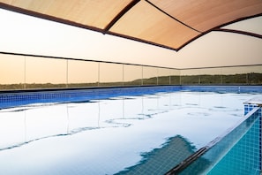 An indoor swimming pool with a clear view of the surrounding landscape.
