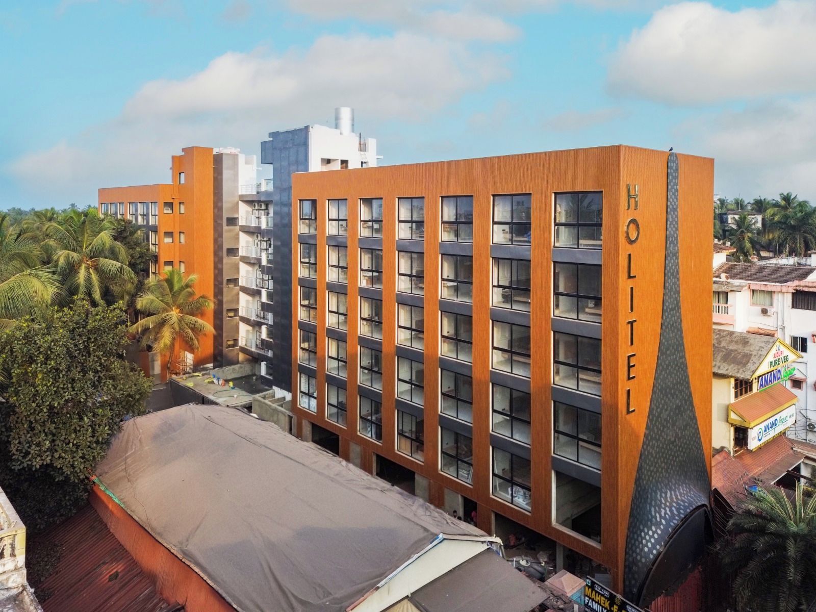 A multi-story hotel building with a prominent 'HOLITEL' sign on the facade.