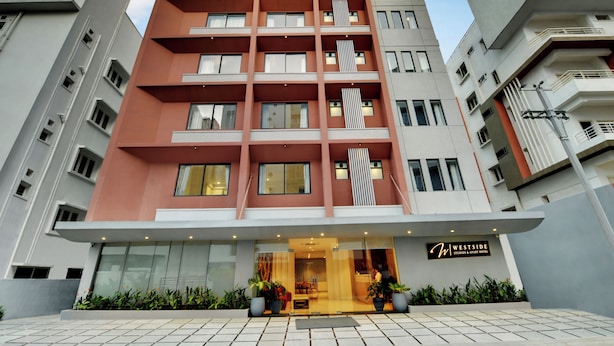 A modern hotel with a flat facade, multiple balconies, and a prominent entrance with a sign. - Westside Studio & Apart Hotel (Hyderabad)