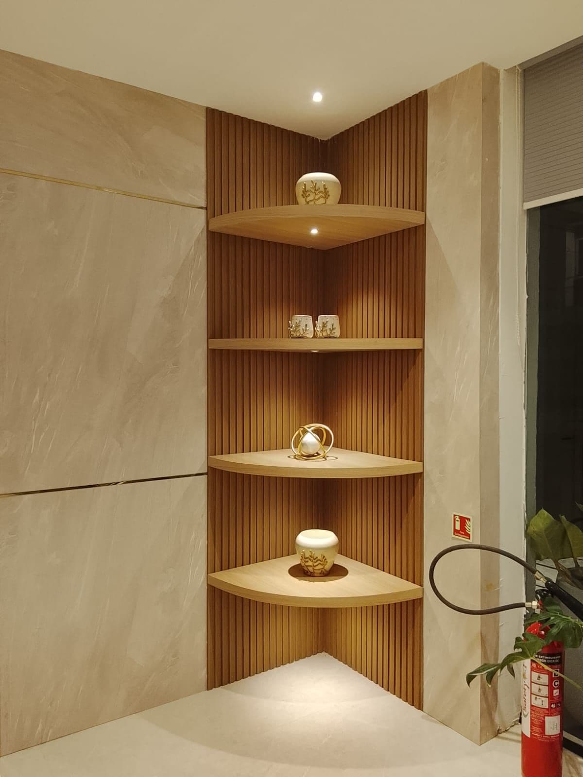 Un rincón con una estantería de madera que exhibe objetos decorativos.