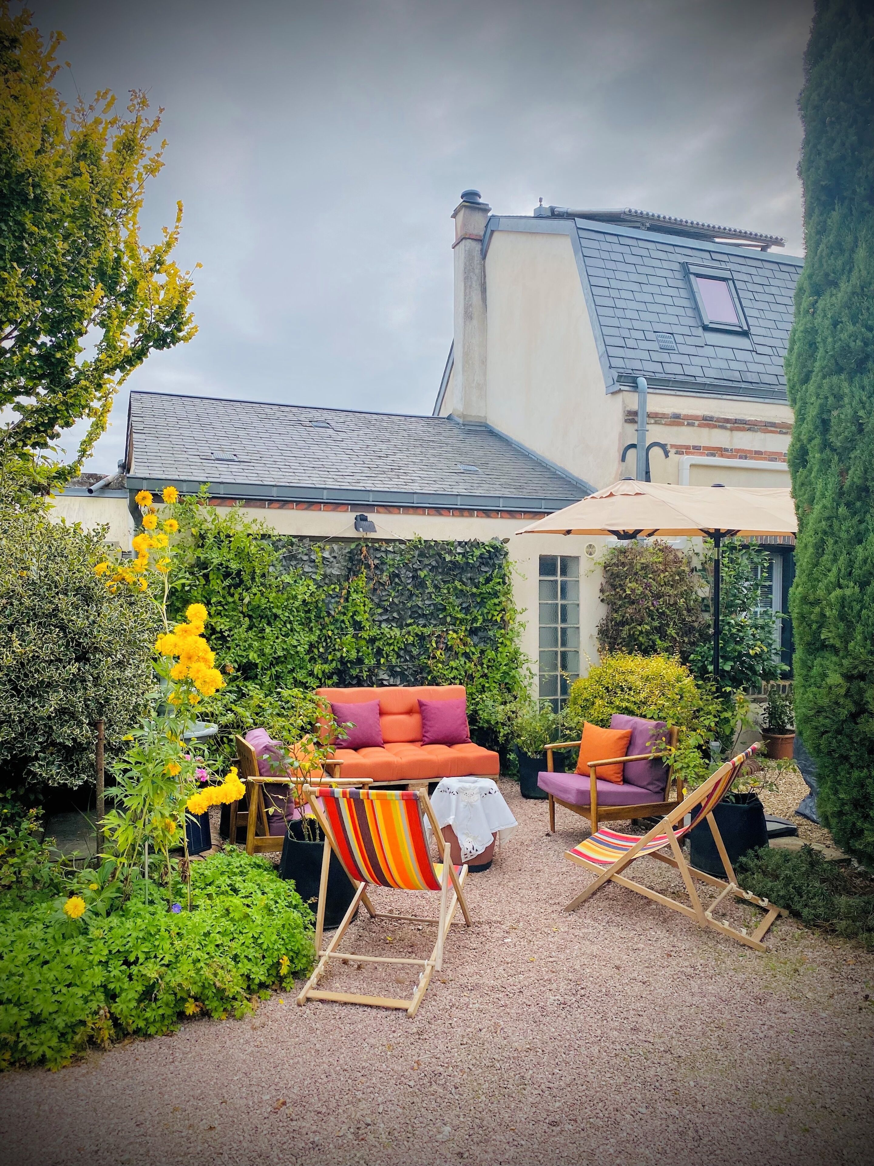 A patio area with a sofa, two chairs, and a table.