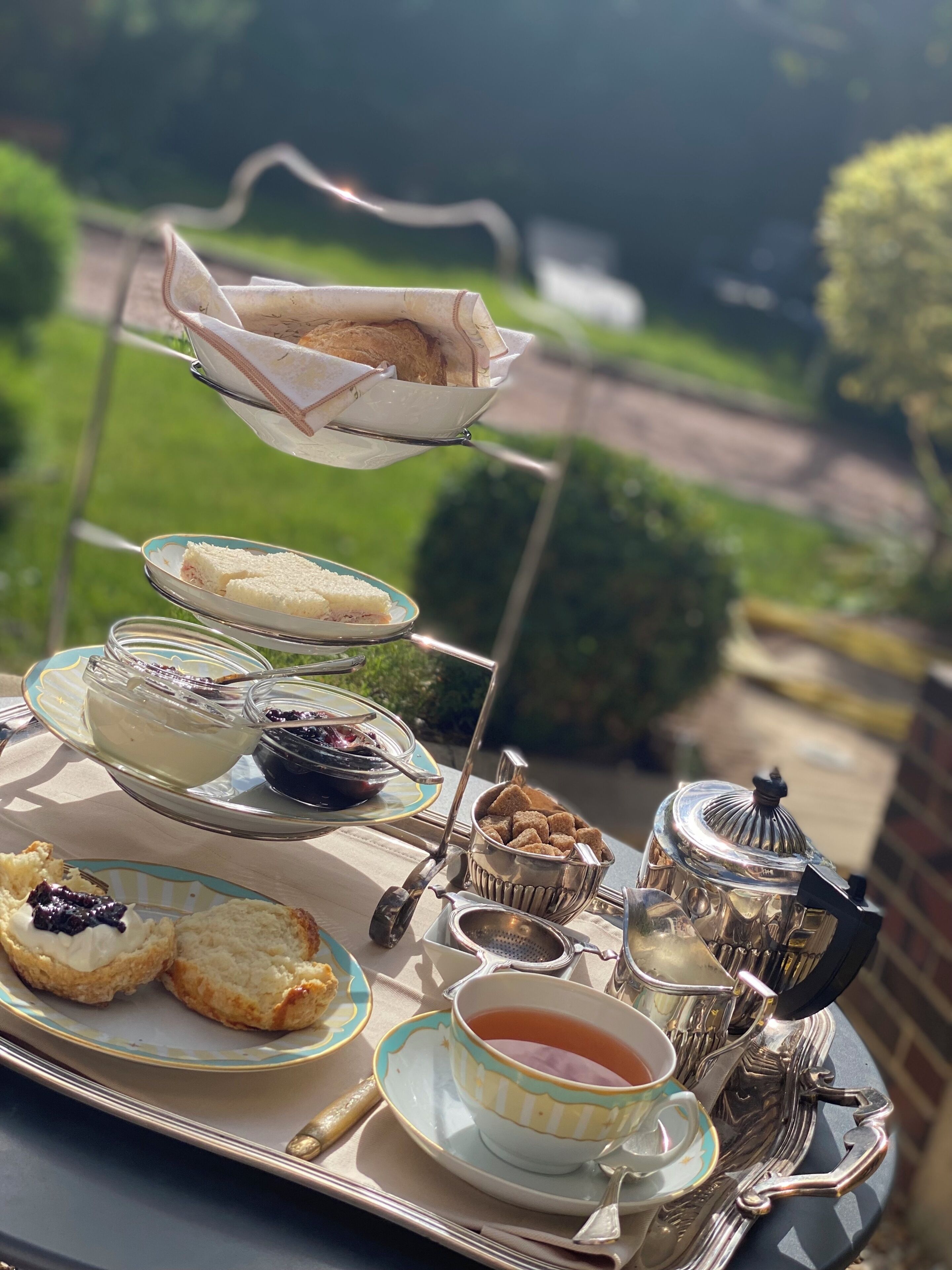Un plateau à étages pour le service du thé, avec des sandwichs, des scones et de la confiture.