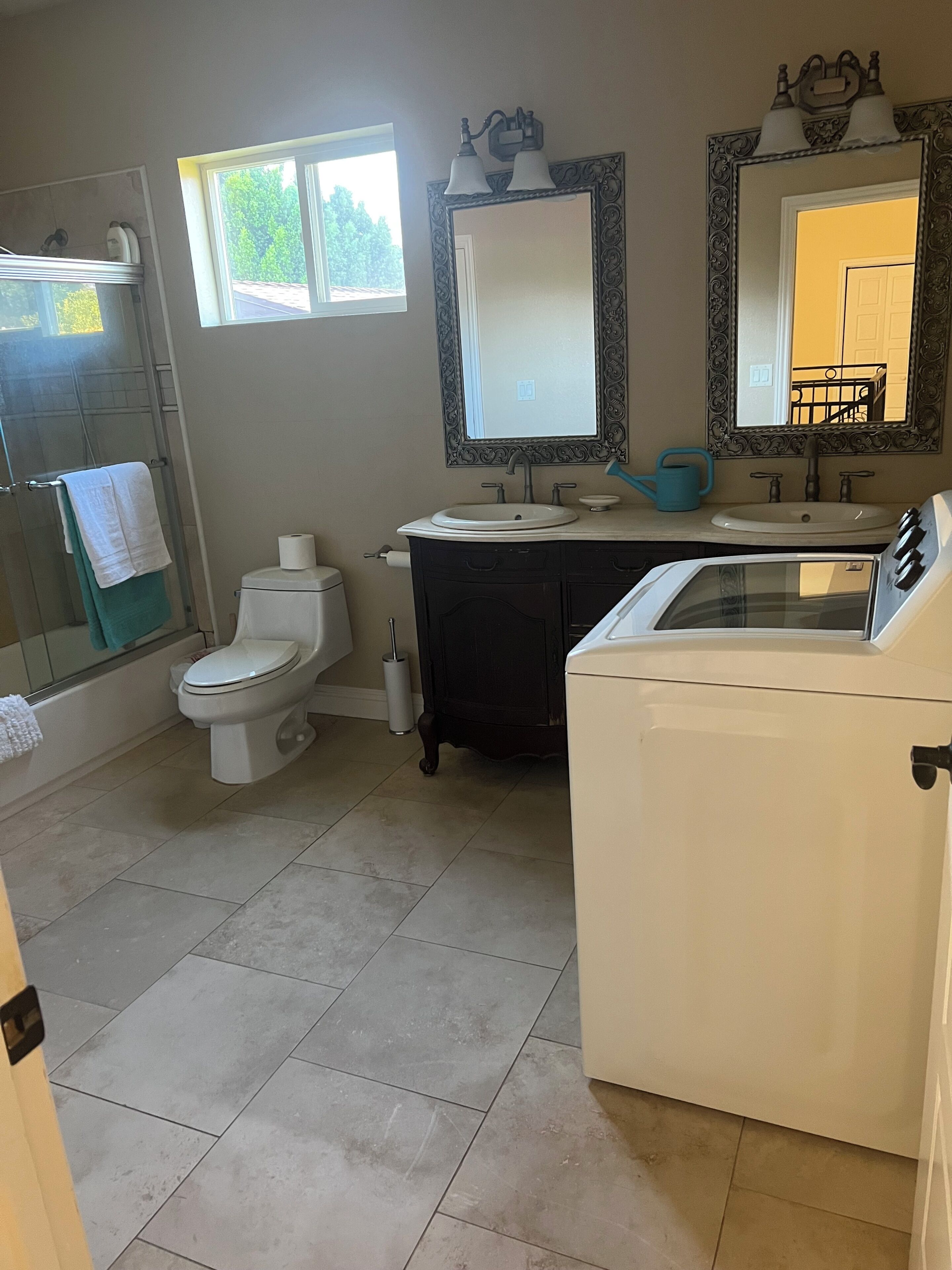 A bathroom with a toilet, sink, and washing machine.