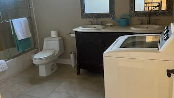 A bathroom with a toilet, sink, and washing machine.