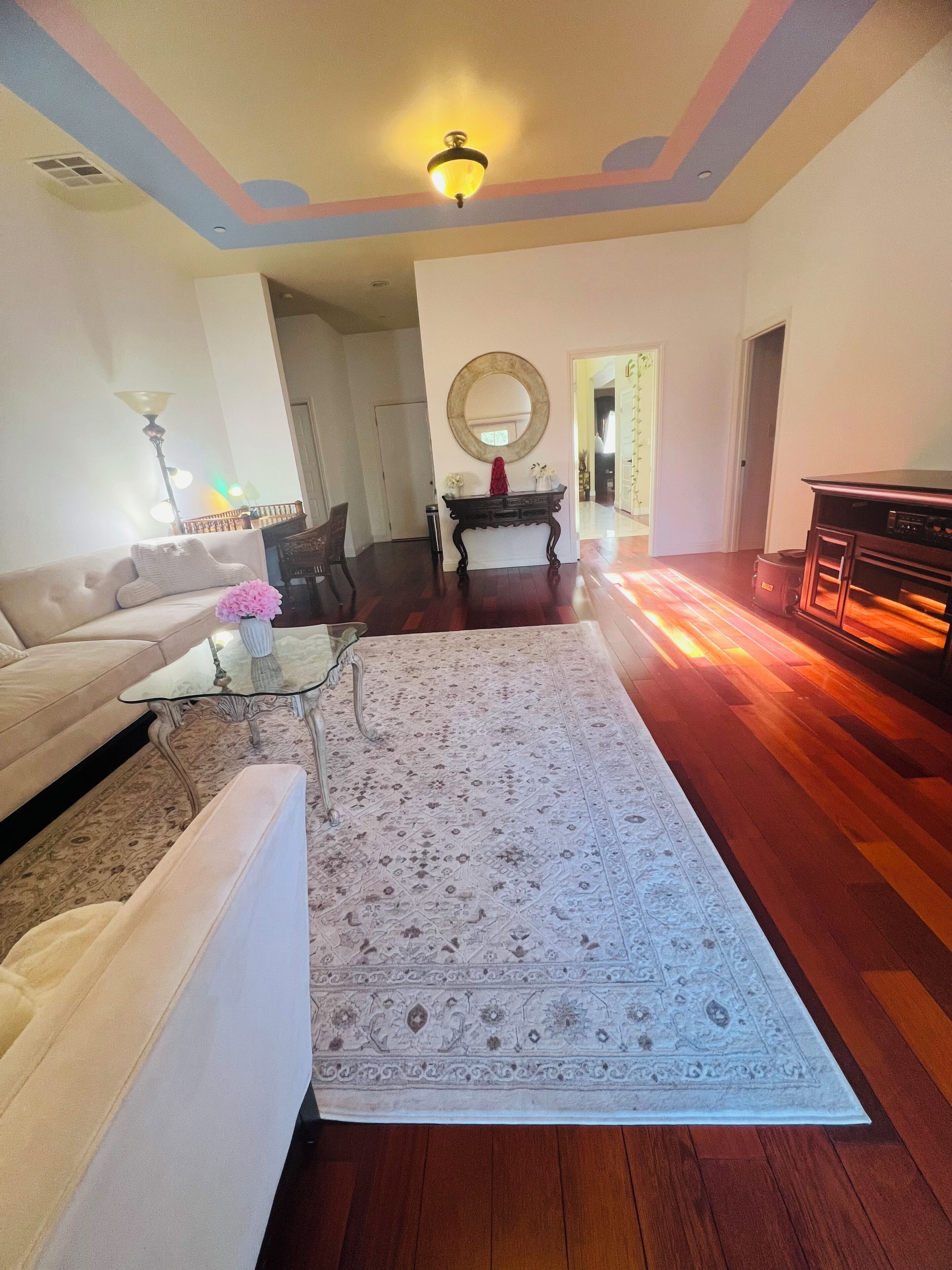 A living room with a sofa, coffee table, and a patterned rug.