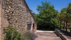 A stone building with a gravel path leading to a wooden door.