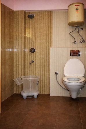 Ein Badezimmer mit Toilette, Dusche und Warmwasserbereiter.