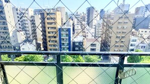 A cityscape with multiple high-rise buildings, a river, and a chain-link fence. - Raku Osaka Daikokucho Namba Shinsaibashi (Osaka)
